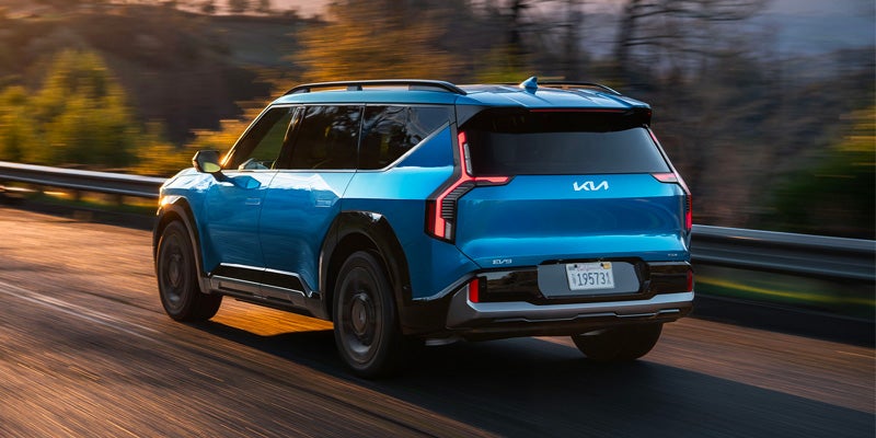 Blue Kia EV9 in motion on the road