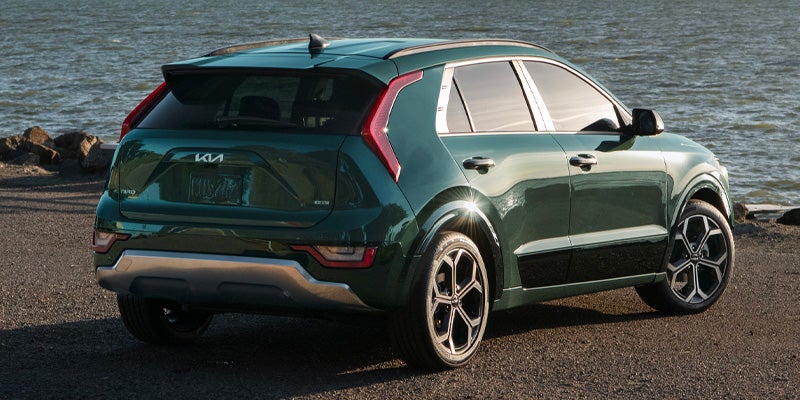 Kia Niro parked outdoors with a scenic lake view in the background.